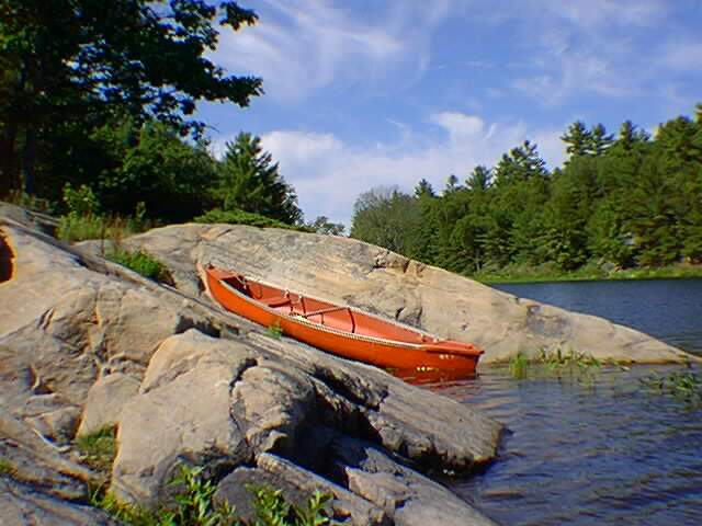A canoe resting between some rocks.